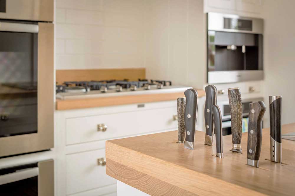 kitchen island doubles as a storage area for slotted knives